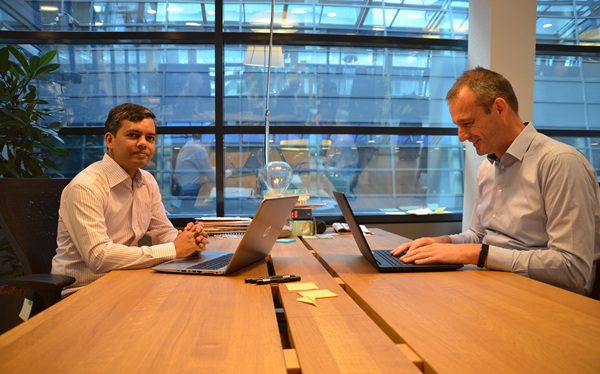 twee collega's aan het werk achter hun laptop