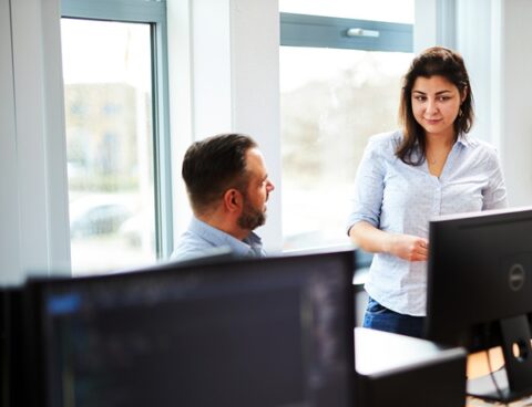 man en vrouw in overleg achter hun laptop